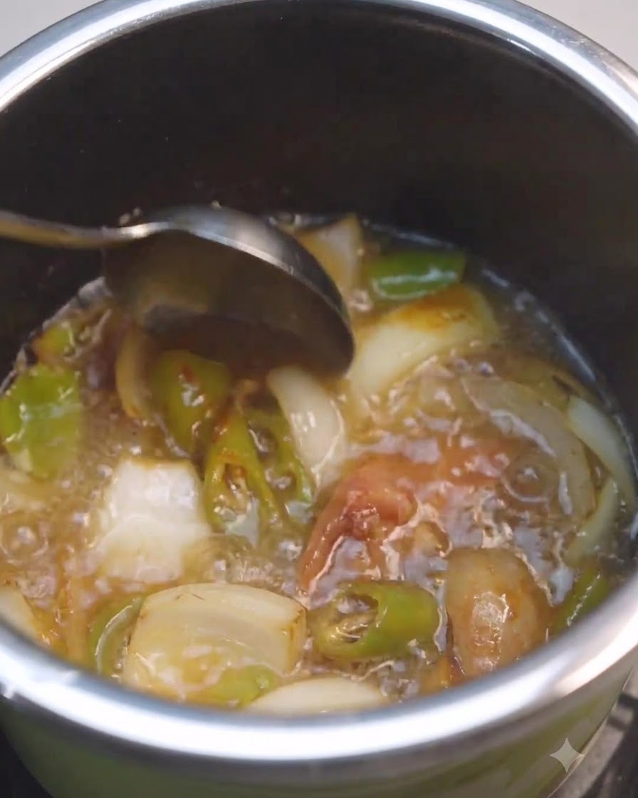 Un cucchiaio che mescola liquido e pasta di soia allinterno di una pentola con verdure.