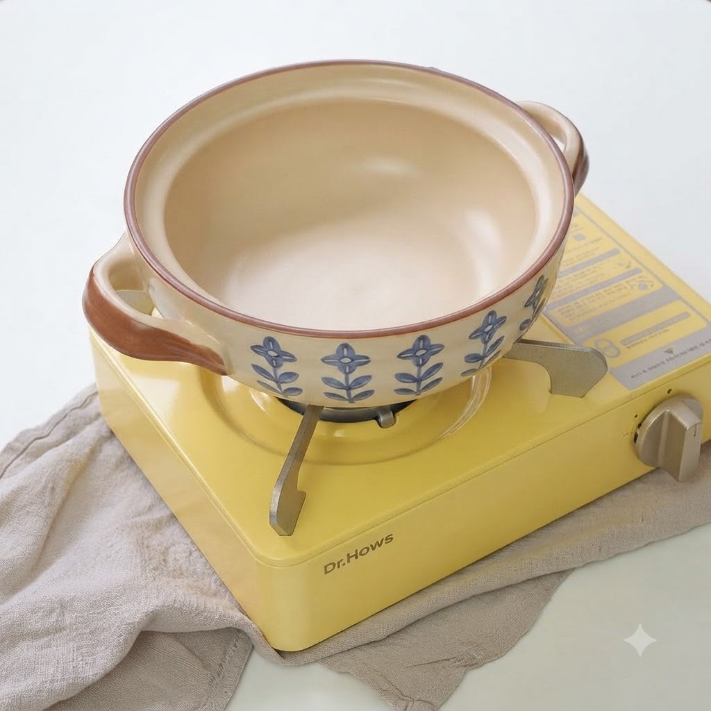 Cipollotti e aglio a fette che sfrigolano in una pentola di ceramica con olio.