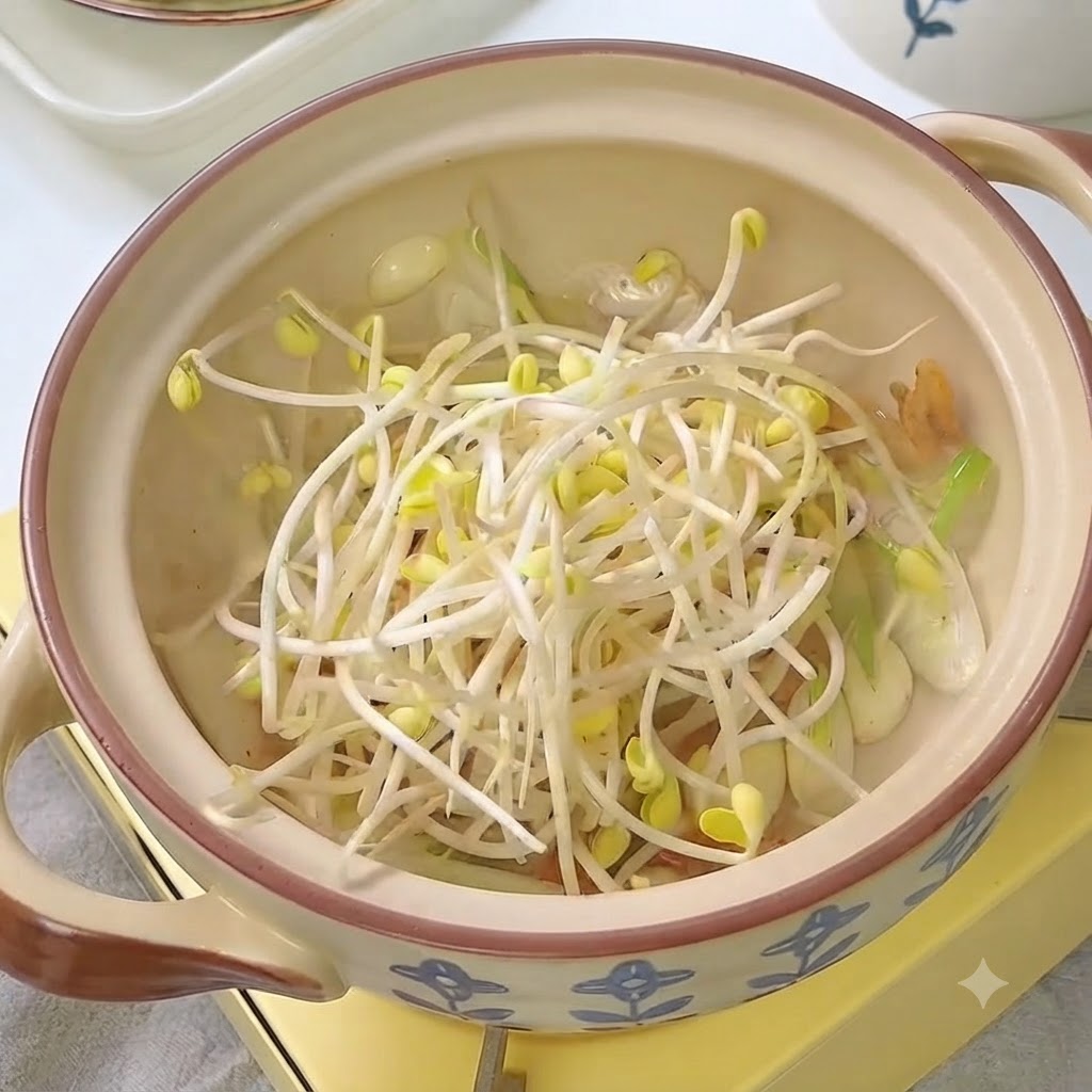 Germogli di soia freschi inseriti nella pentola con kimchi e aromi.