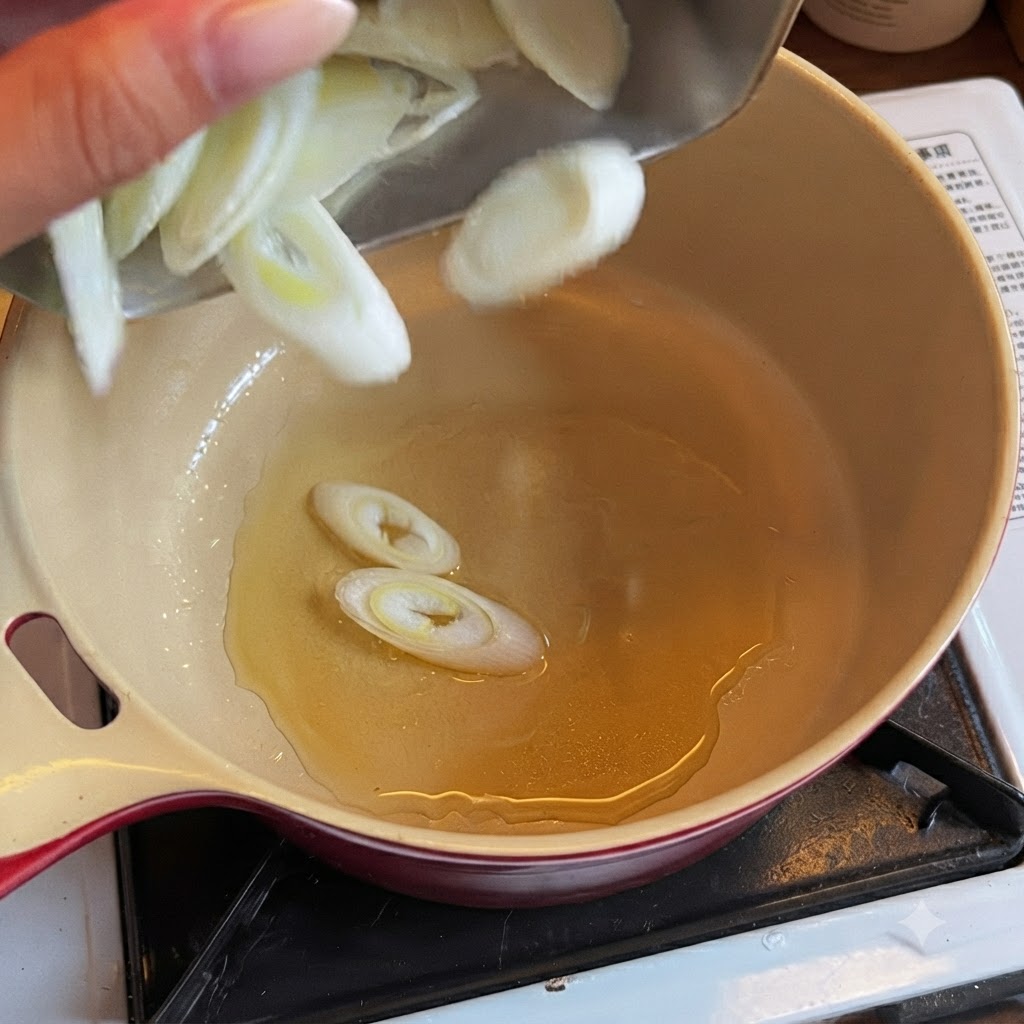 Cipollotti verdi affettati che cadono in una pentola piena di olio da cucina.