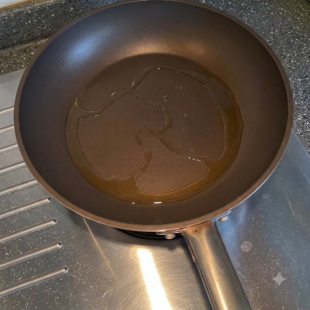 Cipolle gialle affettate che friggono nellolio da cucina allinterno di una padella.