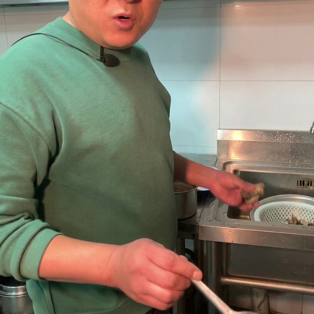 Vongole fresche aggiunte in una pentola di stufato di pasta di soia in ebollizione.