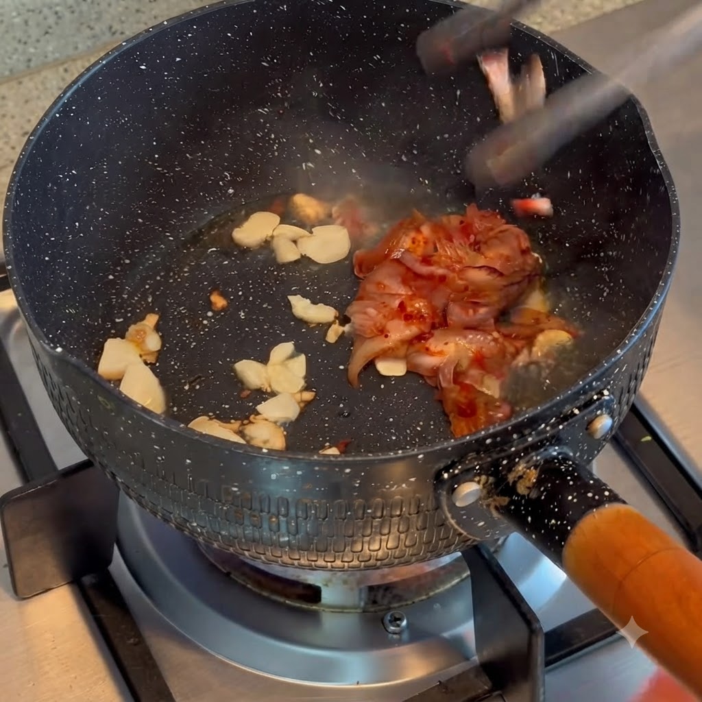 Kimchi saltato in padella insieme allaglio fritto in una pentola.