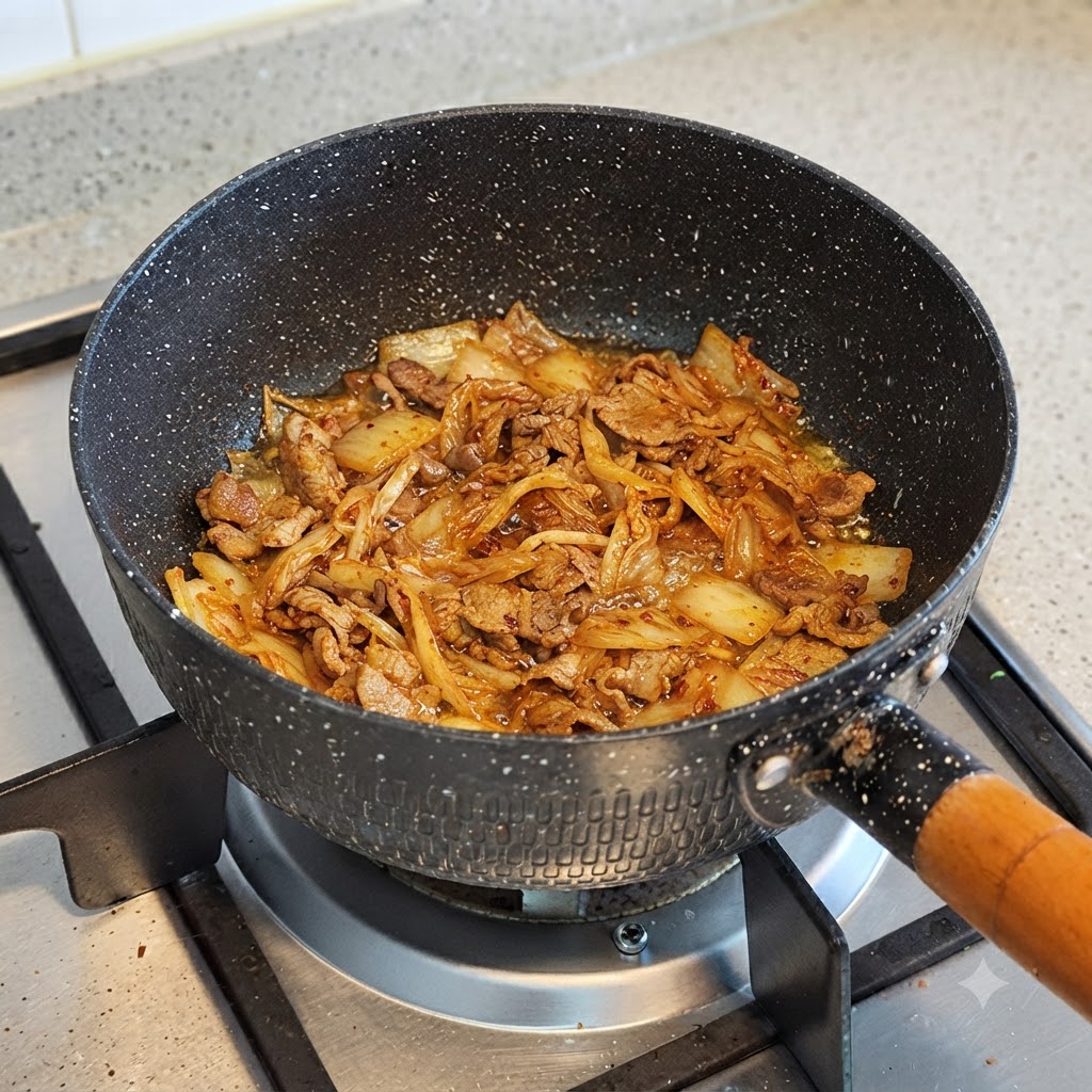 Acqua versata in una pentola contenente kimchi e manzo cotti.
