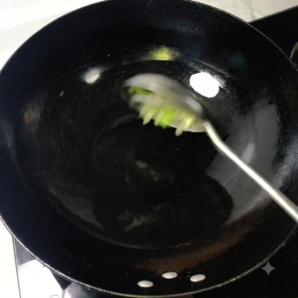 Cipollotti tagliati a pezzi mescolati con un mestolo in olio caldo dentro un wok nero.