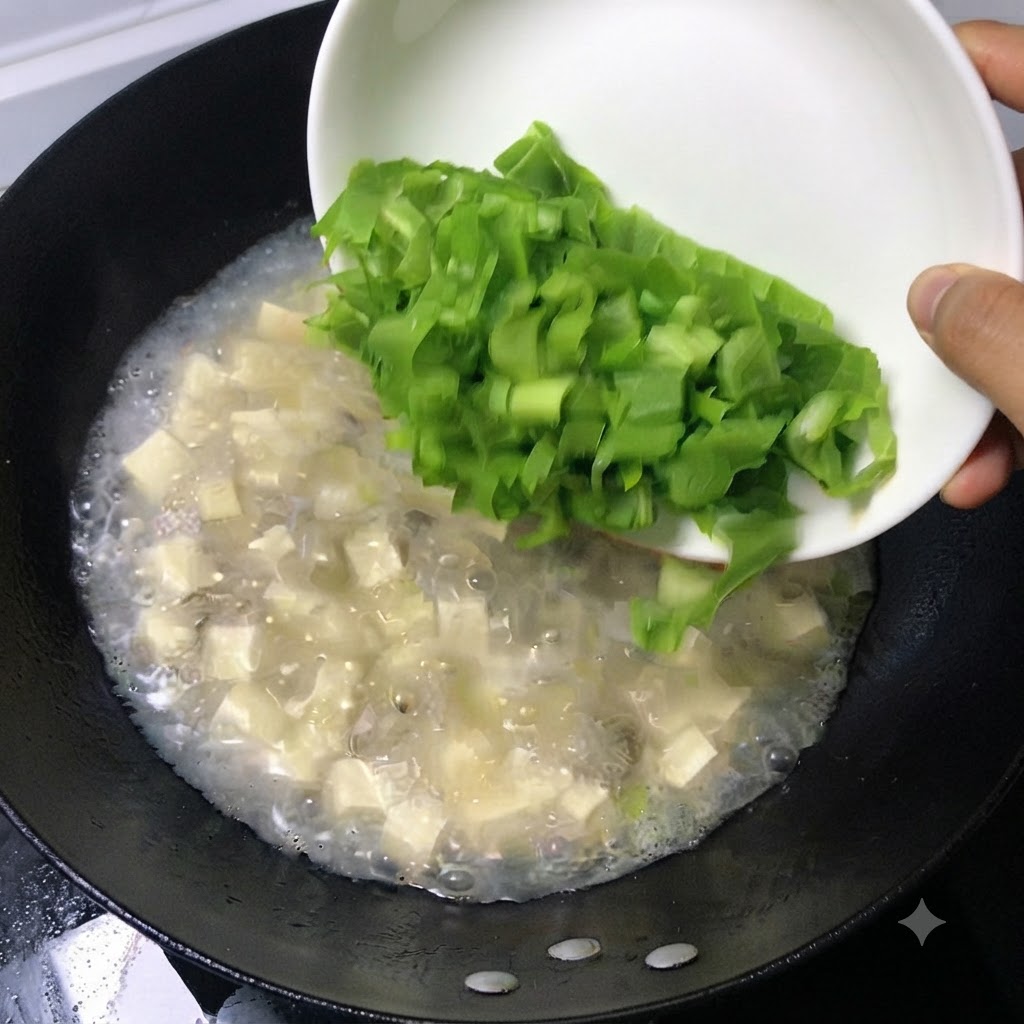Foglie verdi fresche tritate che scivolano da un piatto bianco in una pentola di zuppa bollente.