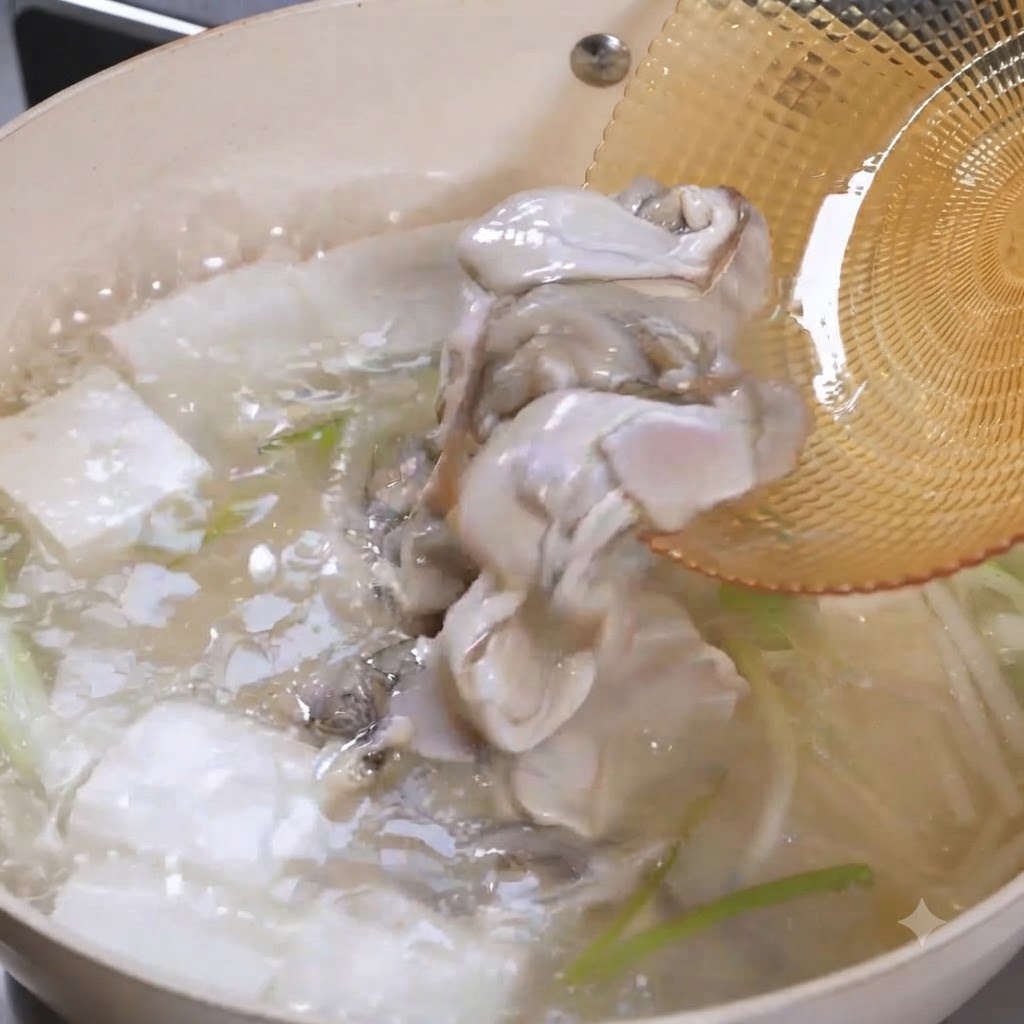 Polpa di ostrica cruda che scivola da una schiumarola in una pentola ribollente di zuppa di tofu.