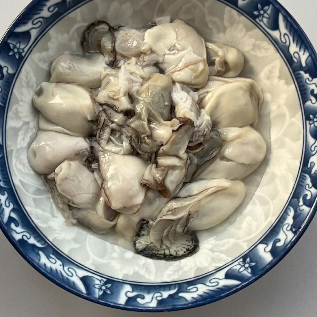Una ciotola riempita di ostriche crude sgusciate e risciacquate di fresco.