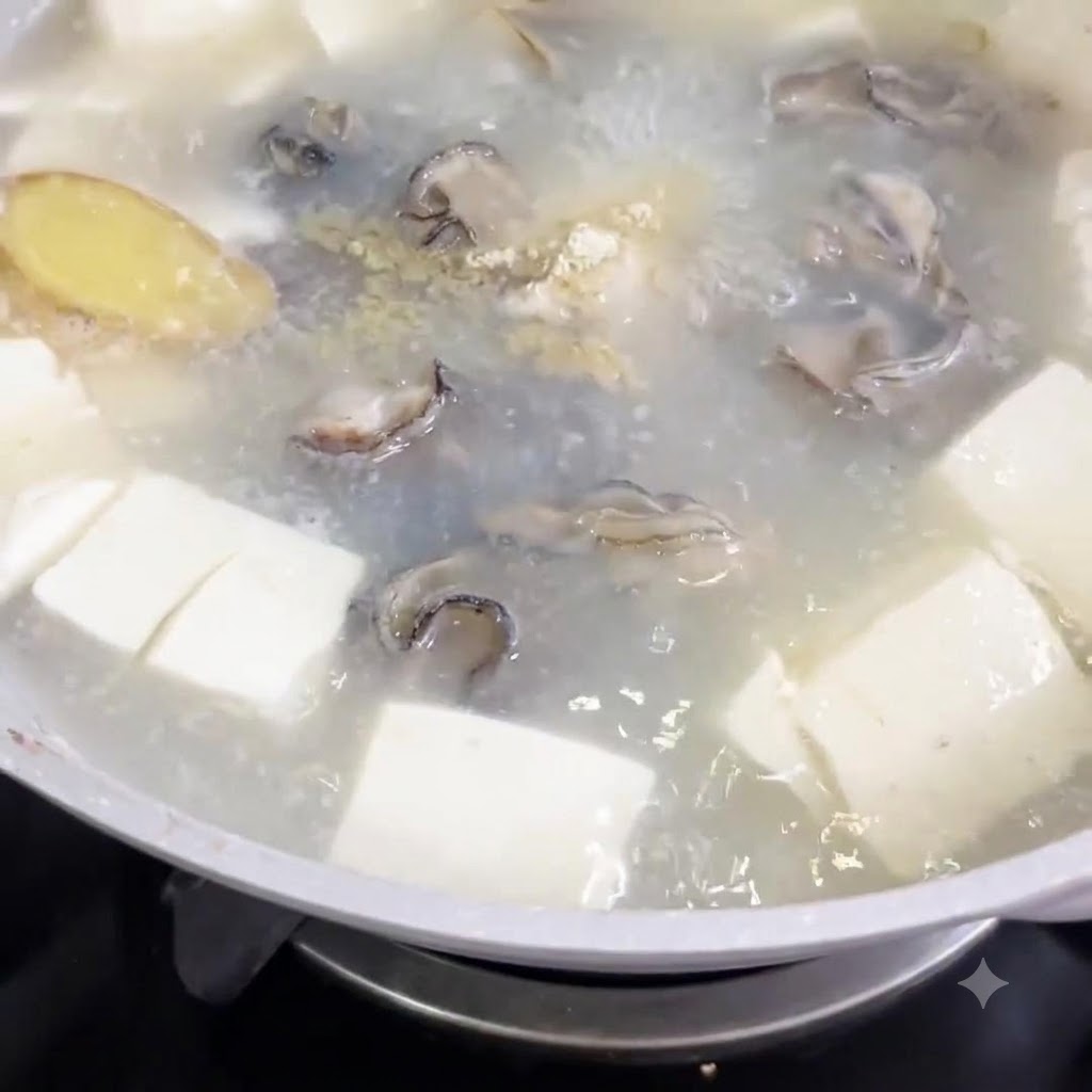 Pepe bianco in polvere spolverato in una pentola di zuppa bollente con cubetti di tofu e ostriche.