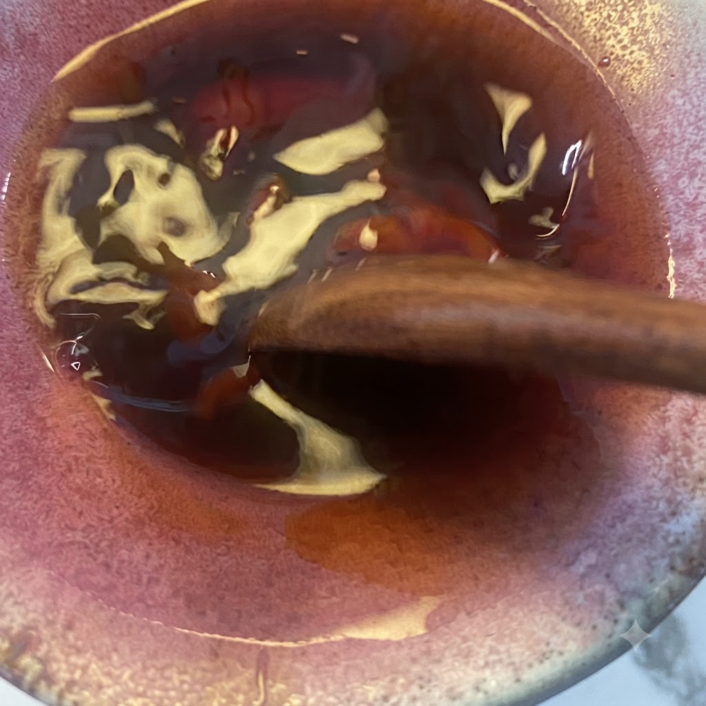 La miscela di salsa teriyaki mescolata con un cucchiaio di legno nella ciotola.