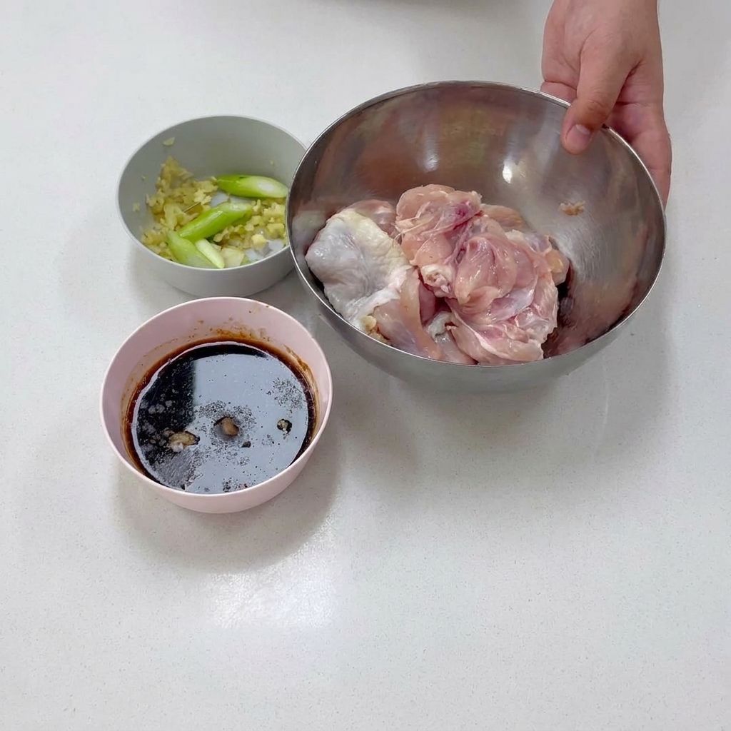 Carne di coscia di pollo disossata adagiata allinterno di una ciotola in acciaio inossidabile durante la preparazione.