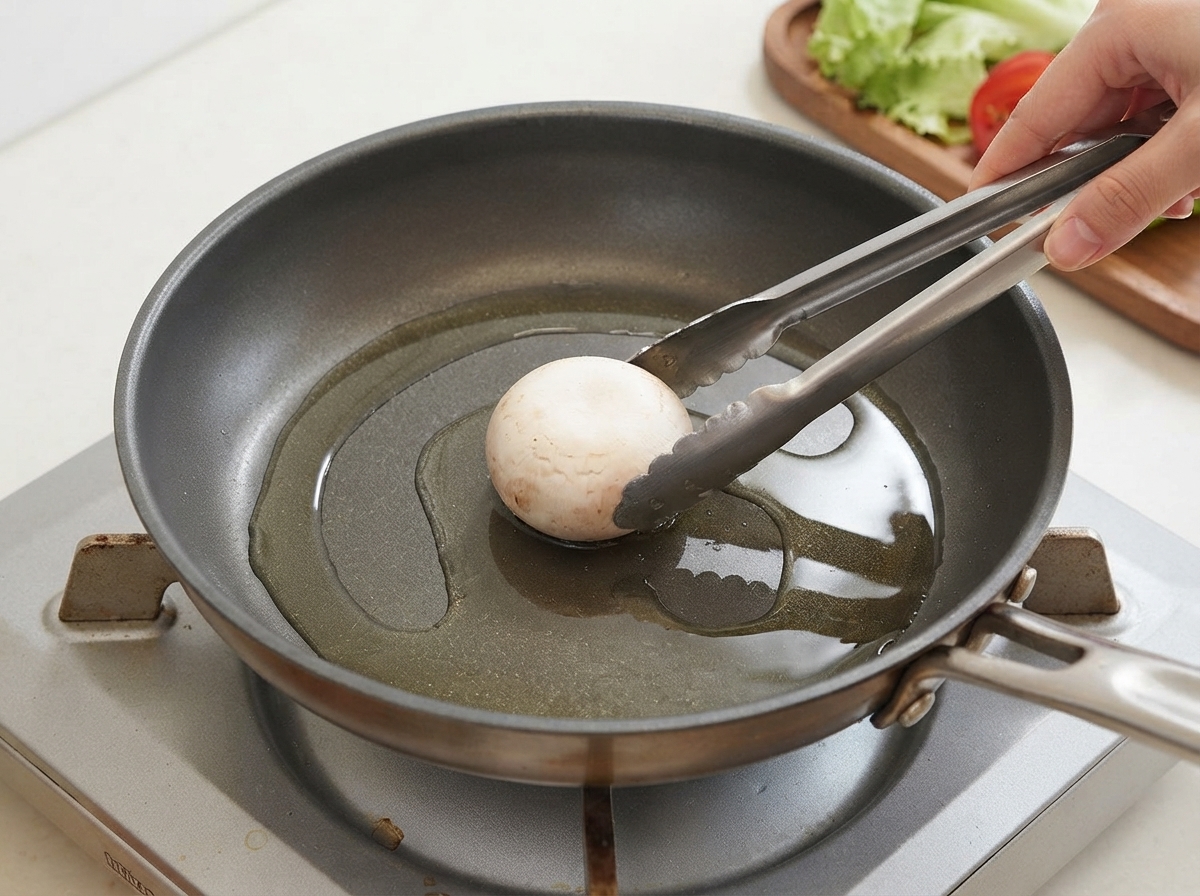 Un singolo fungo posizionato in una padella oliata con le pinze.