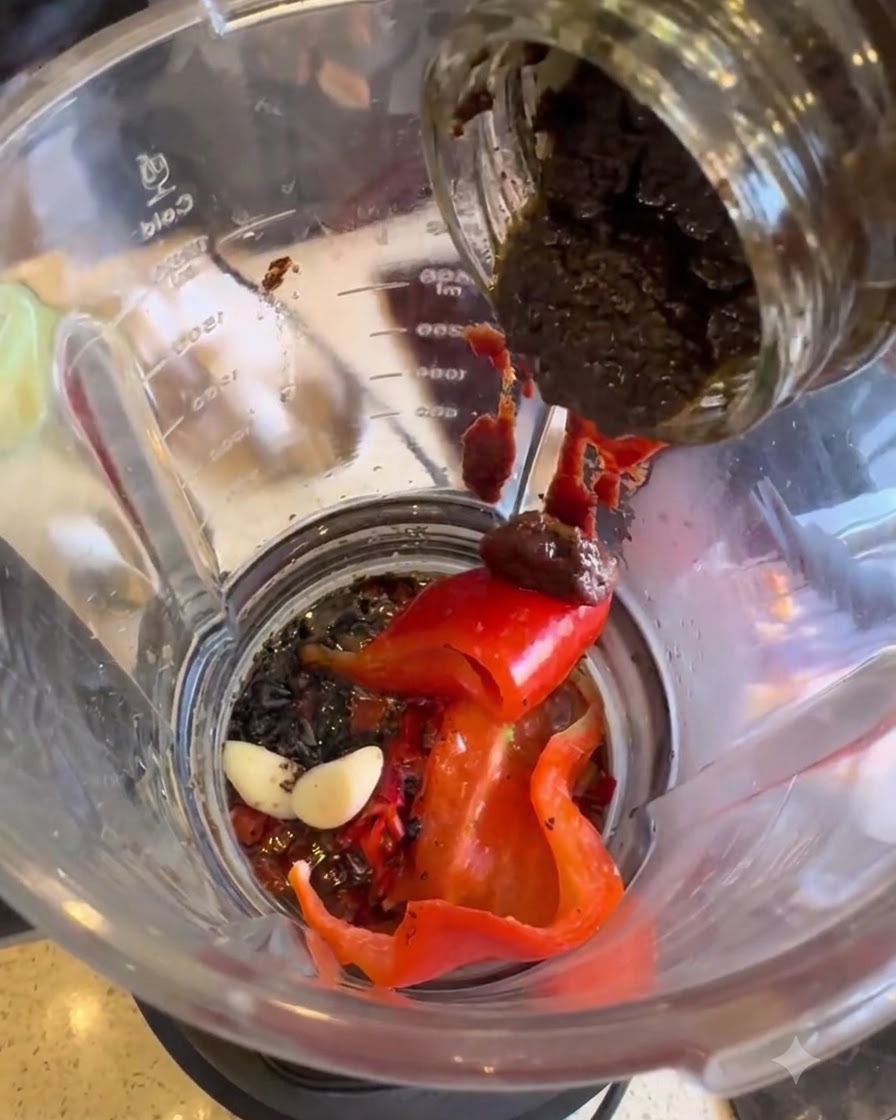 Pasta di tartufo nero trasferita da un barattolo nel frullatore.