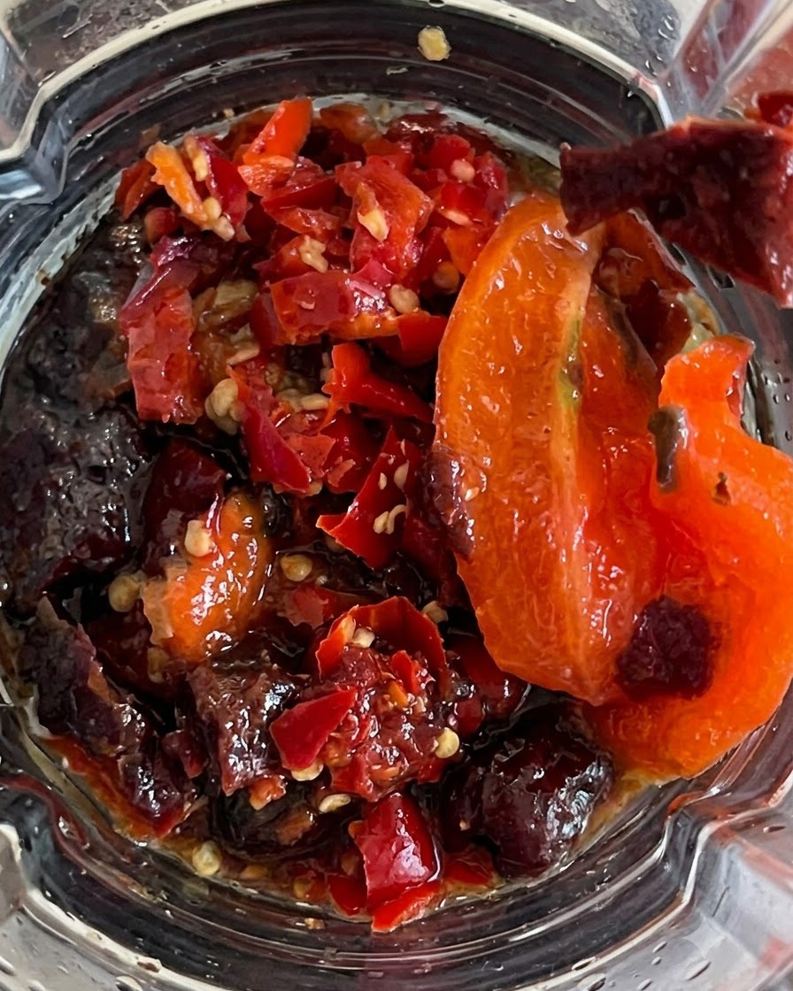 Tutti gli ingredienti frullati allinterno del contenitore in una salsa piccante densa.
