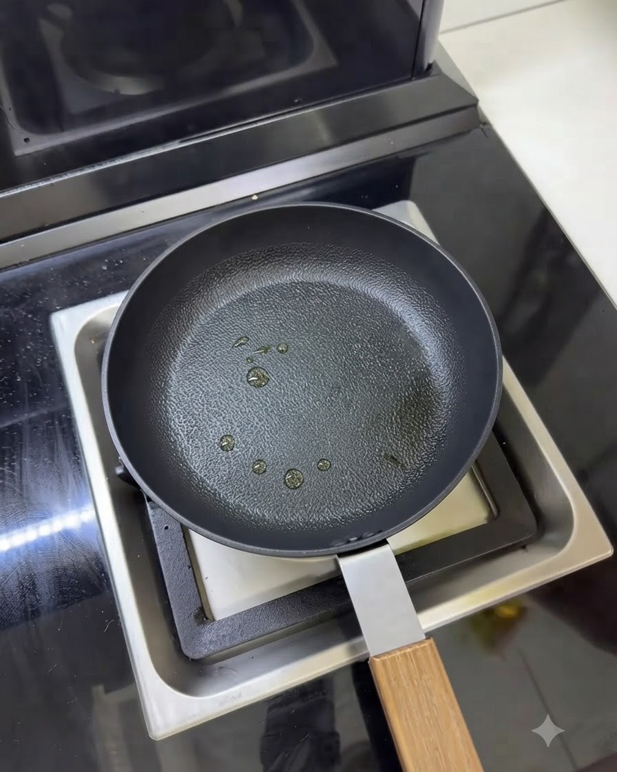 Una padella con piccole gocce di olio da cucina vaporizzate sulla superficie.
