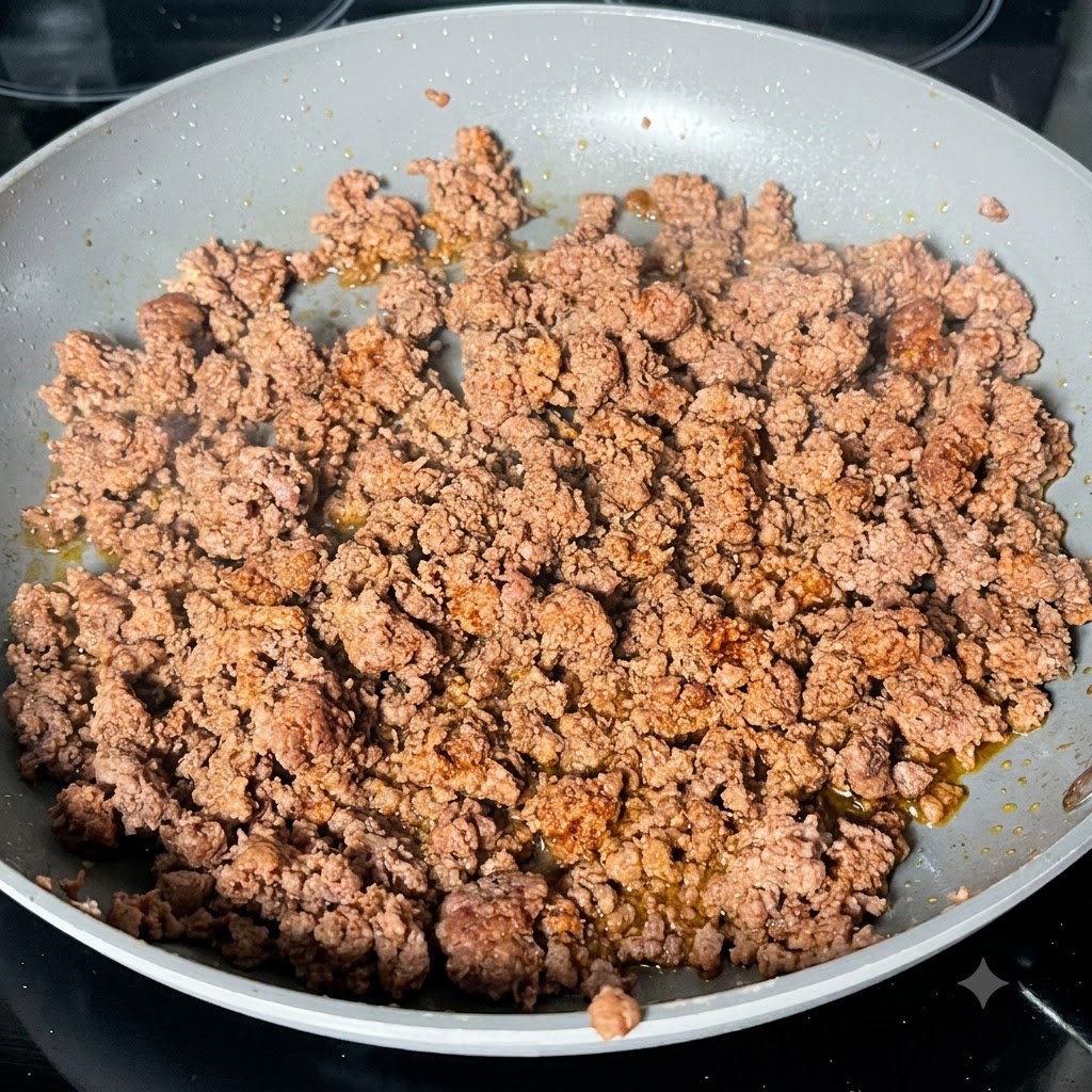 Salsa Worcestershire scura versata sulla carne macinata rosolata in una padella.