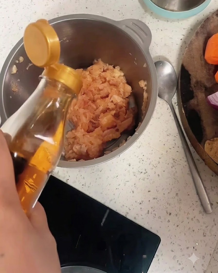 Vino da cucina versato da una bottiglia in una ciotola di acciaio inossidabile piena di pollo macinato e pepe.