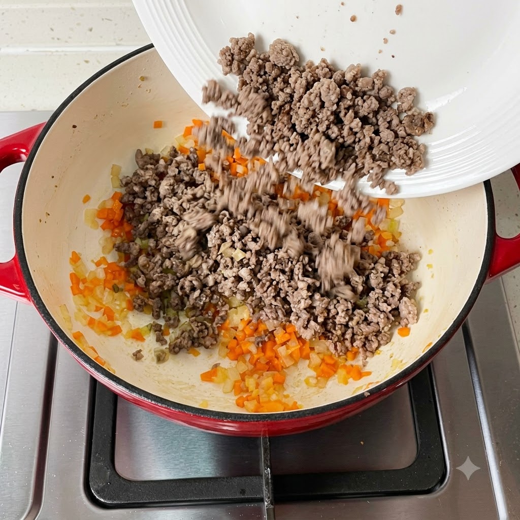 Carne macinata cotta aggiunta nuovamente nella padella contenente le verdure.