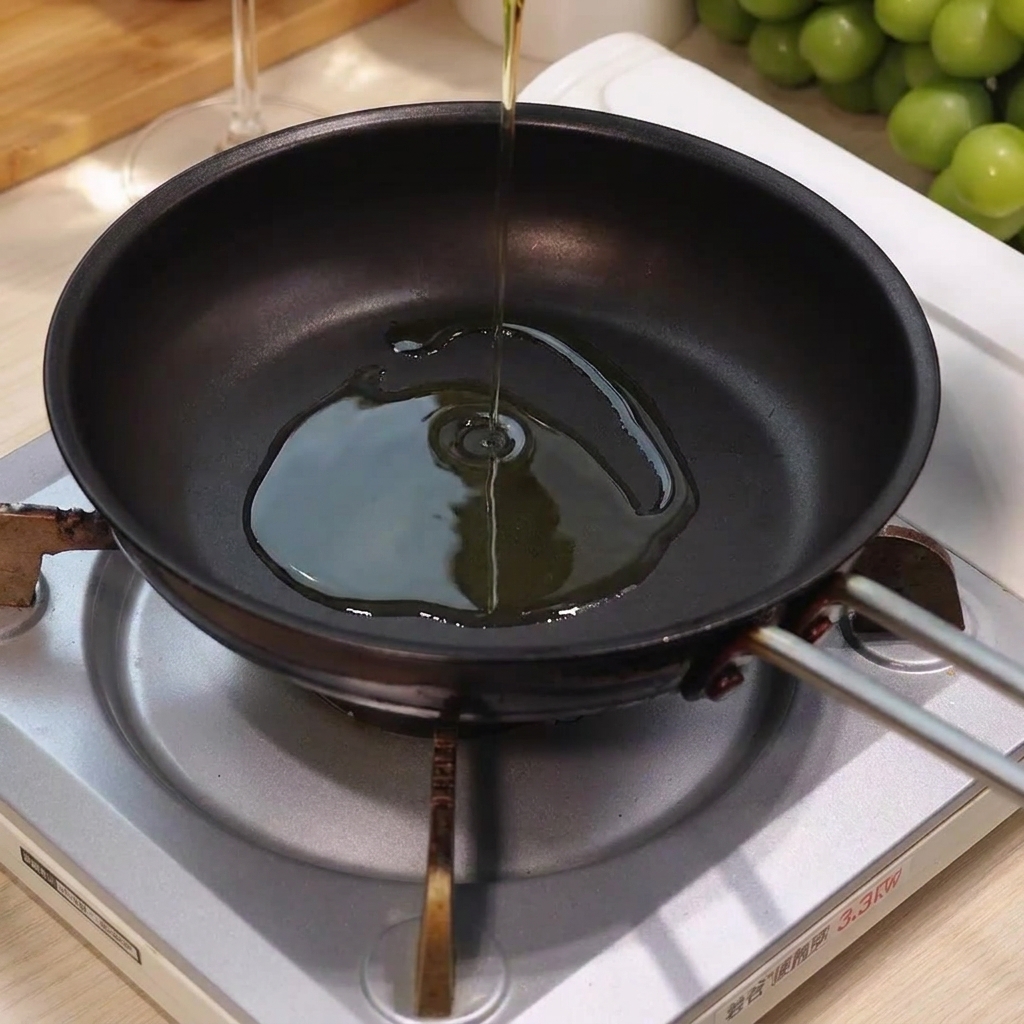 Olio doliva versato al centro di una padella calda e vuota posta su un fornello.