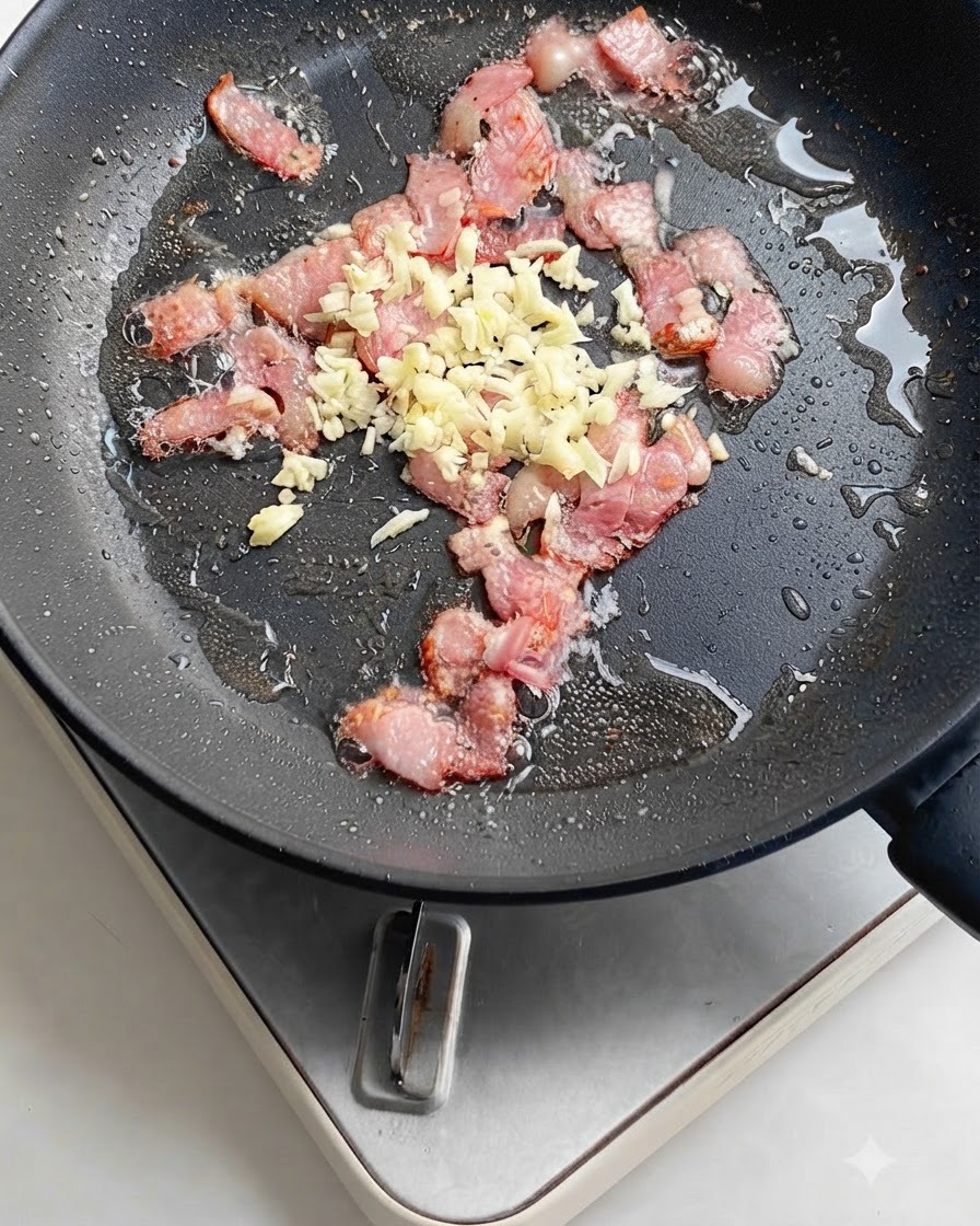 Fettine di peperoncino rosso vivo aggiunte alla padella con pancetta e aglio sfrigolanti.
