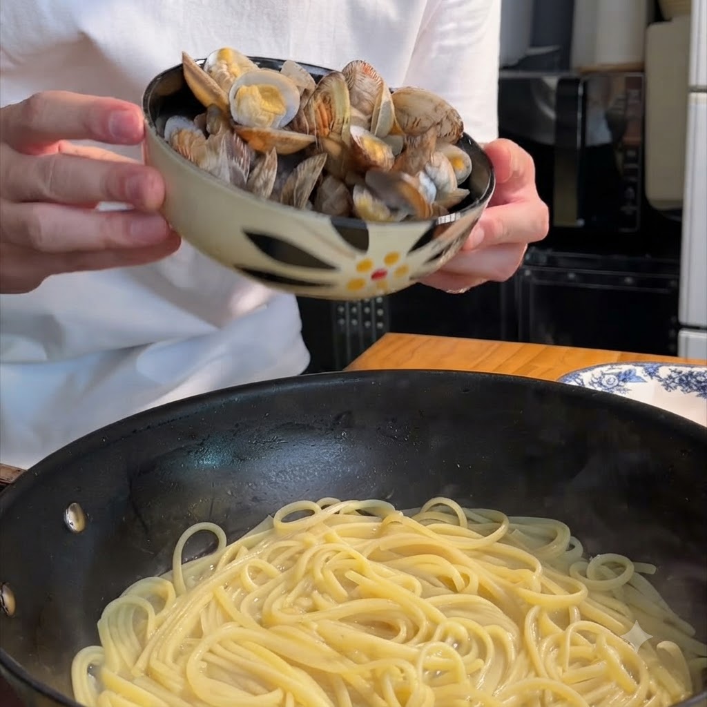Una persona che tiene una ciotola decorata e versa le vongole cotte in una padella piena di spaghetti.