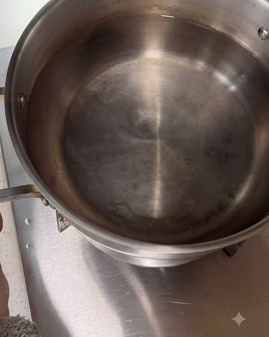 Pentola in acciaio inossidabile piena dacqua posizionata su un fornello.