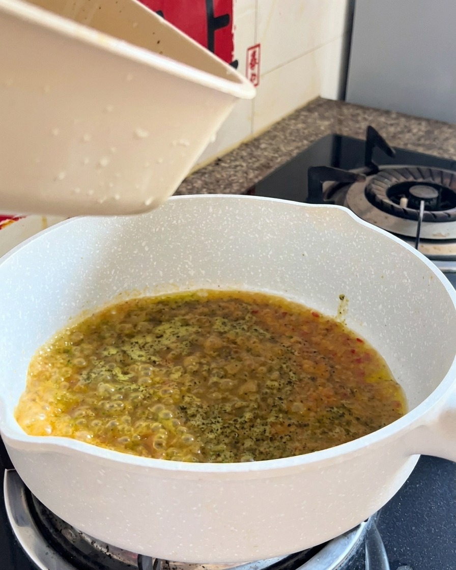 Spaghetti cotti e liquido uniti in padella durante la mantecatura finale.