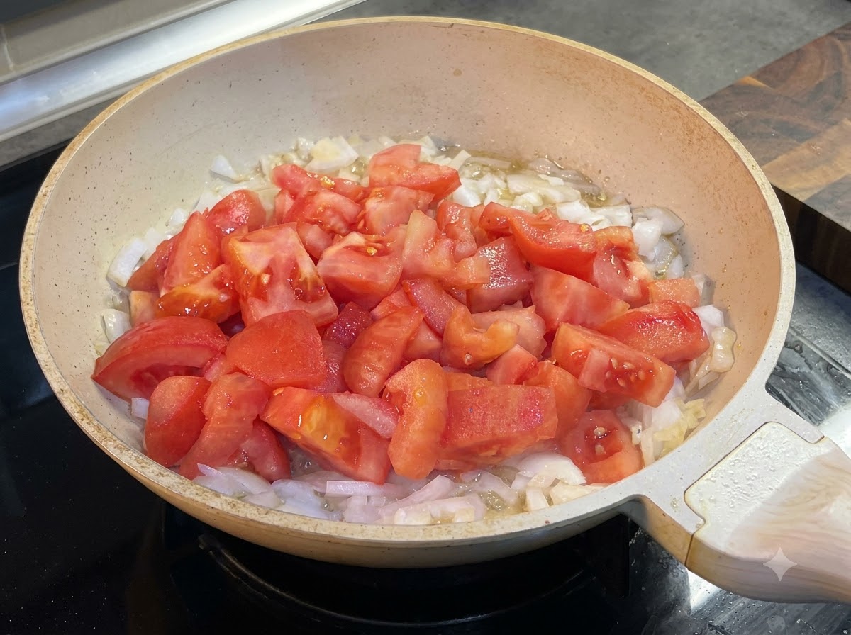 Ketchup aggiunto nella padella con pomodori e cipolle.
