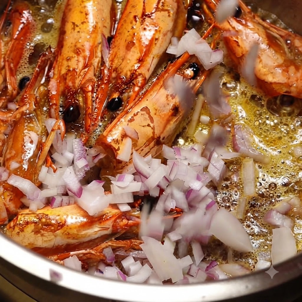 Cipolle rosse tritate finemente gettate in una pentola contenente teste di gamberi in frittura e olio caldo.