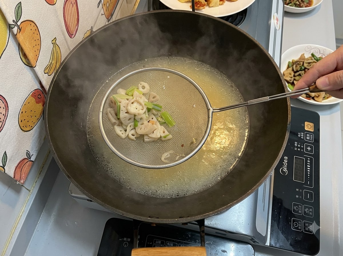 Una schiumarola di metallo che trattiene pezzi solidi filtrati sopra un wok pieno di un brodo cremoso giallognolo in ebollizione.