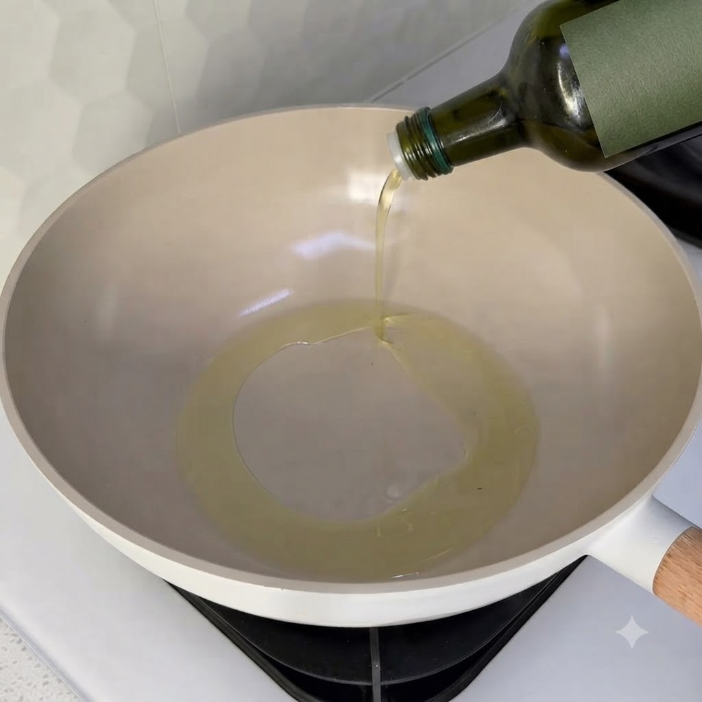 Olio da cucina versato in un wok pulito su un fornello.