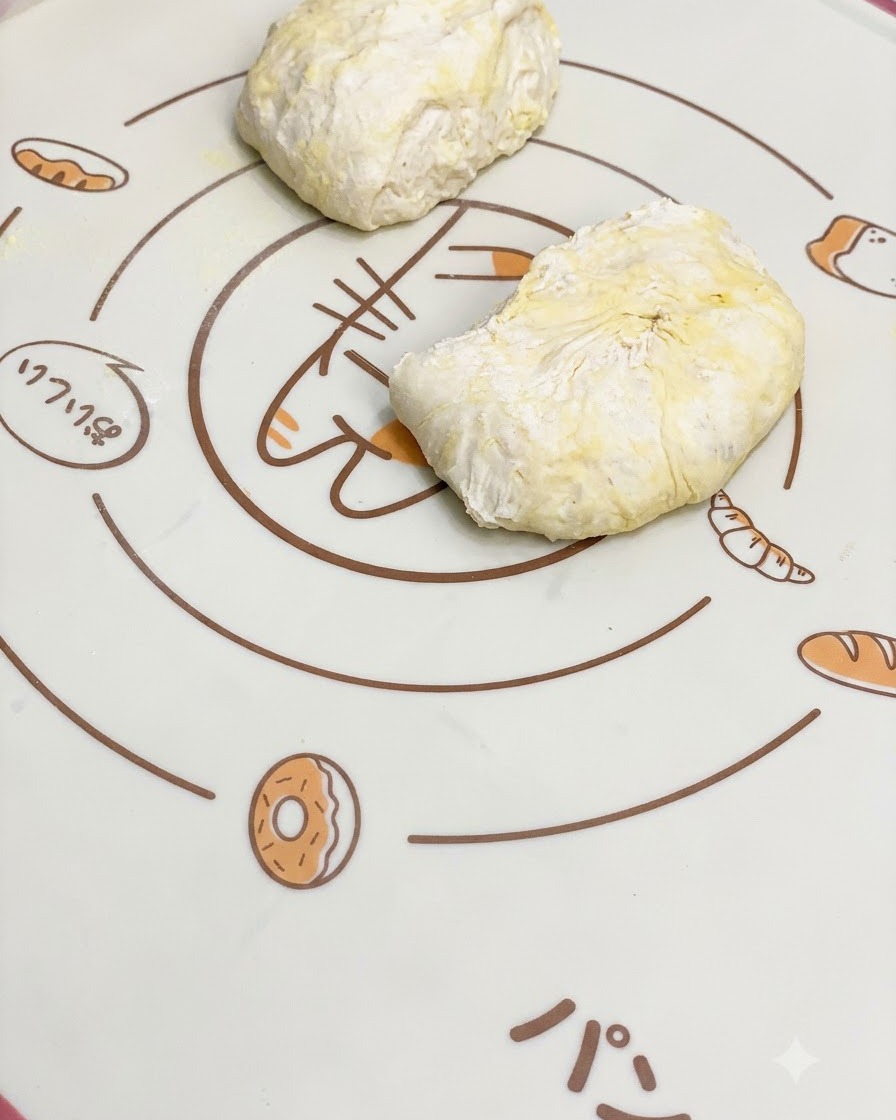 Panetti di impasto per pizza lievitati che riposano su un tappetino da forno in silicone con motivi.