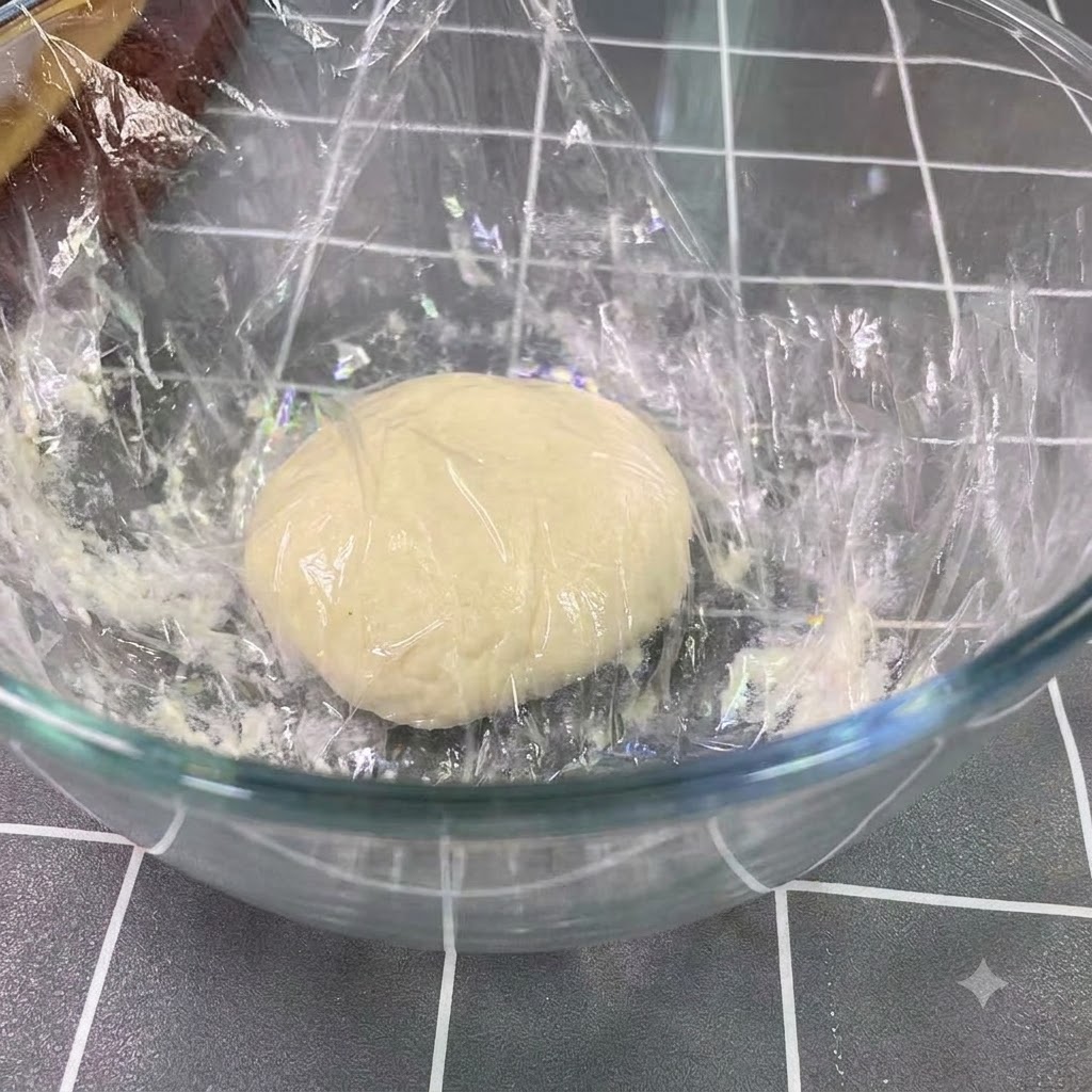 Impasto fermentato in riposo e lievitato fino al doppio della sua dimensione in una grande ciotola di vetro.