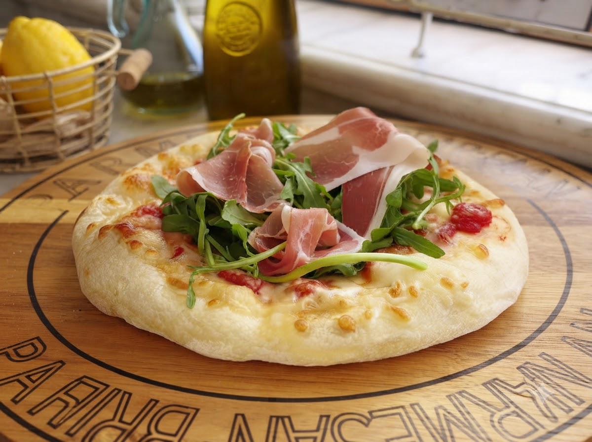 Formaggio Parmigiano appena affettato che cade su una pizza preparata con verdure e carne stagionata.