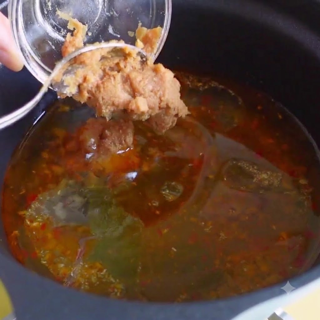 Bouillon di pollo, estratto di bonito e pasta di chili coreana mescolati nel brodo della zuppa.