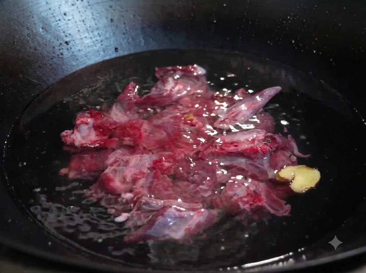 Costine di manzo crude sommerse in acqua fredda in un wok con fette di zenzero e un cipollotto.