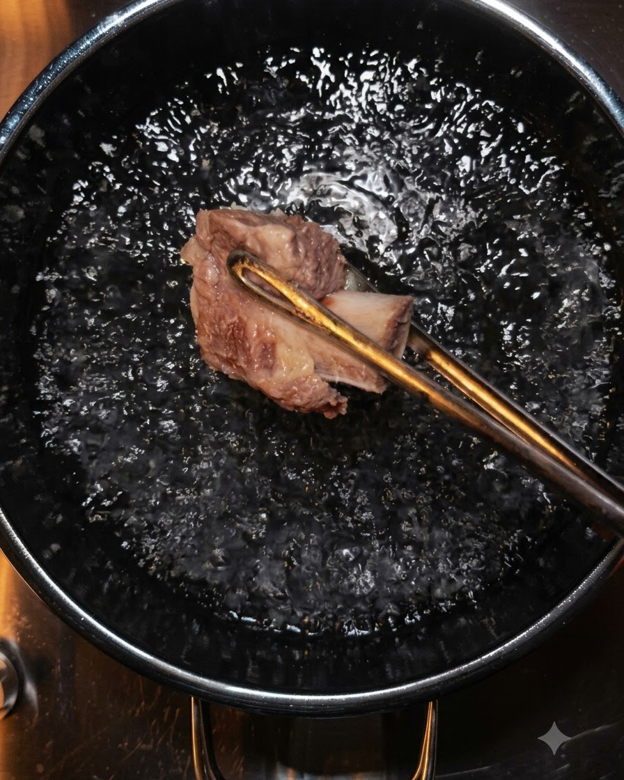 Pinze che sollevano un pezzo di manzo dallacqua bollente.