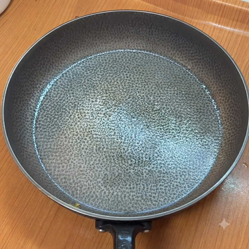 Una padella vuota riscaldata con una superficie ruvida su un bancone da cucina.