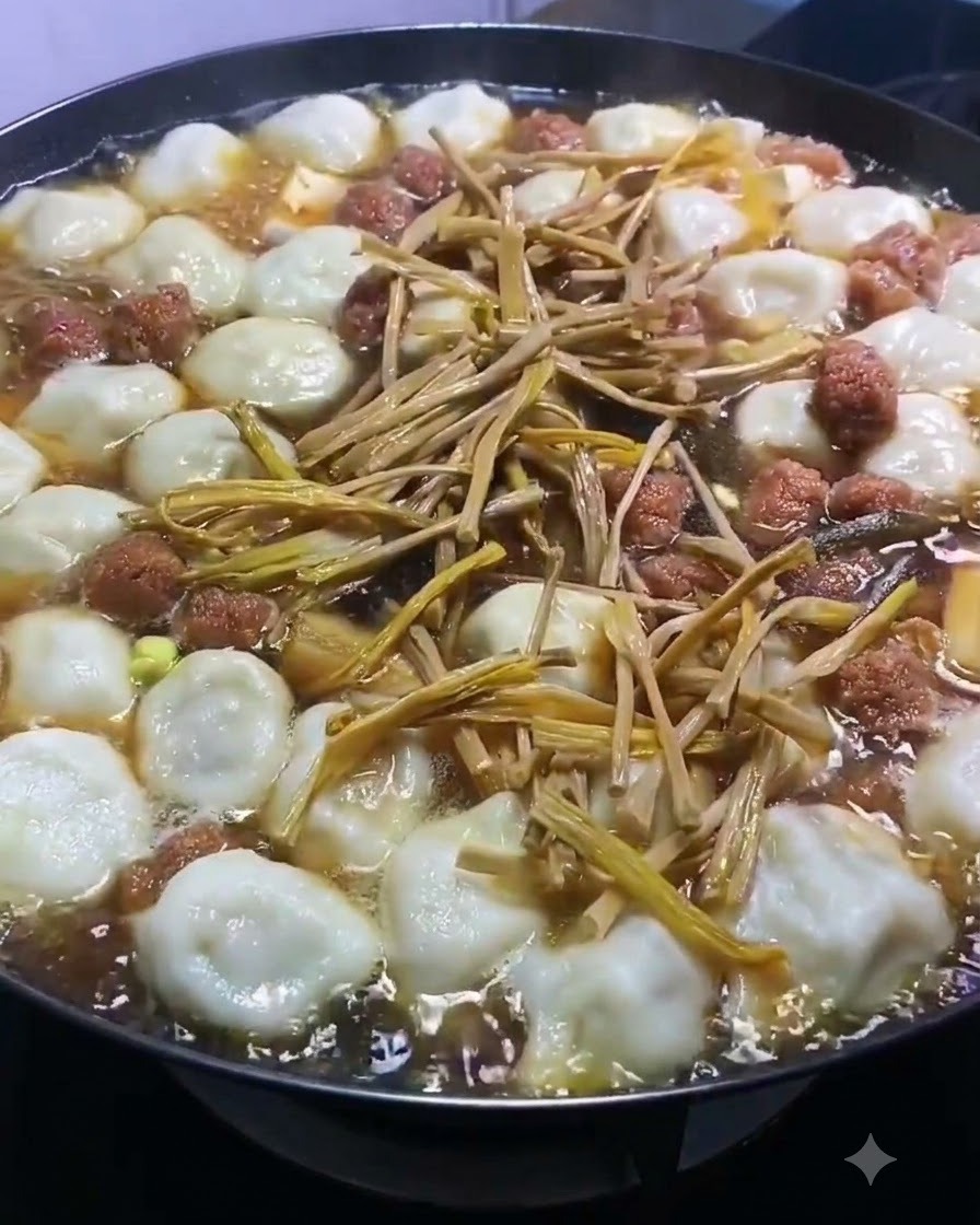 Gigli essiccati sparsi sopra la pentola bollente di dumpling e ingredienti della zuppa.