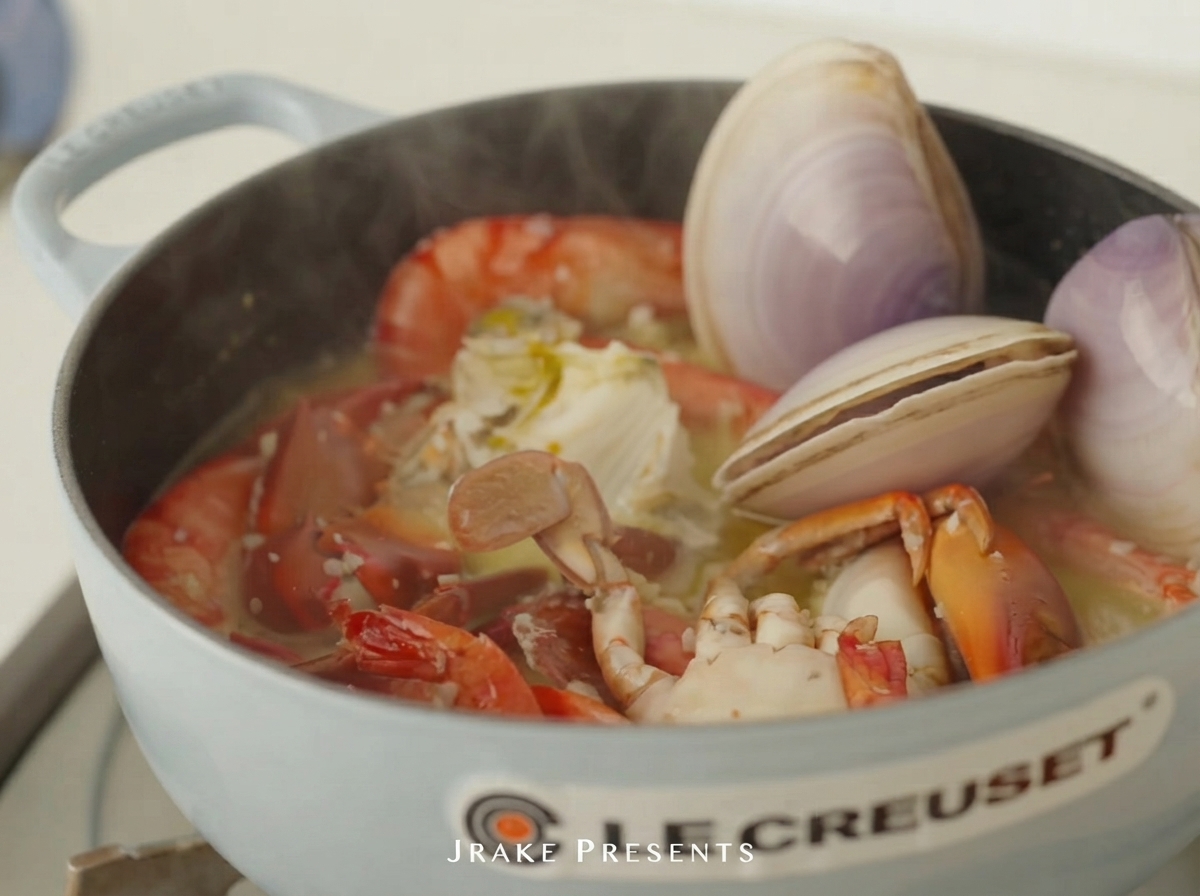 Vongole crude e abalone posti nella pentola con gamberi e granchio.