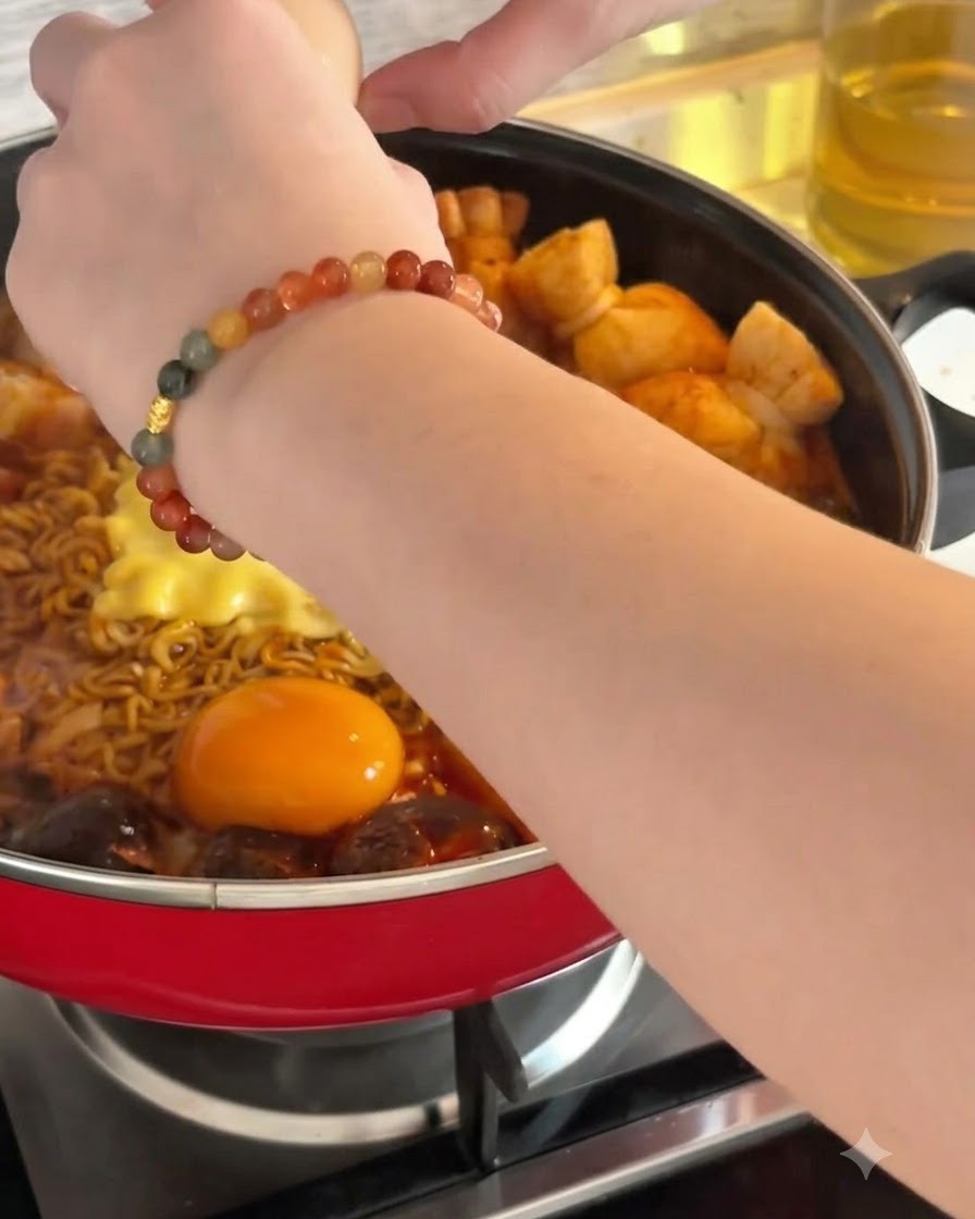 Un uovo crudo viene rotto nel brodo bollente accanto ai noodle e al formaggio.