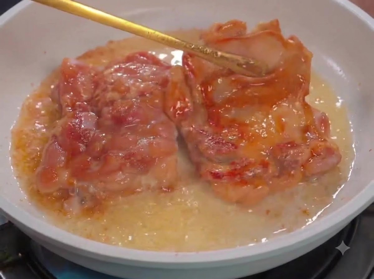 Pinze da cucina che girano i pezzi di pollo in una padella bianca con olio.