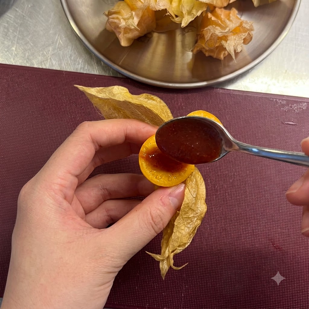 Un cucchiaino che aggiunge un cucchiaio di salsa chili rossa nel centro cavo di unuva spina affettata.