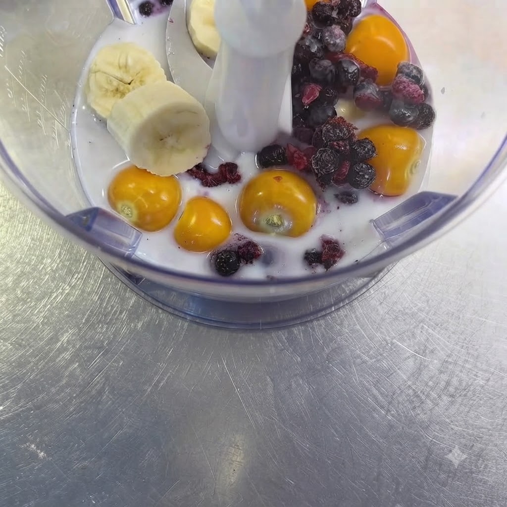 Uno spicchio daglio crudo appoggiato tra la frutta e il mix di latte allinterno della tazza del frullatore.