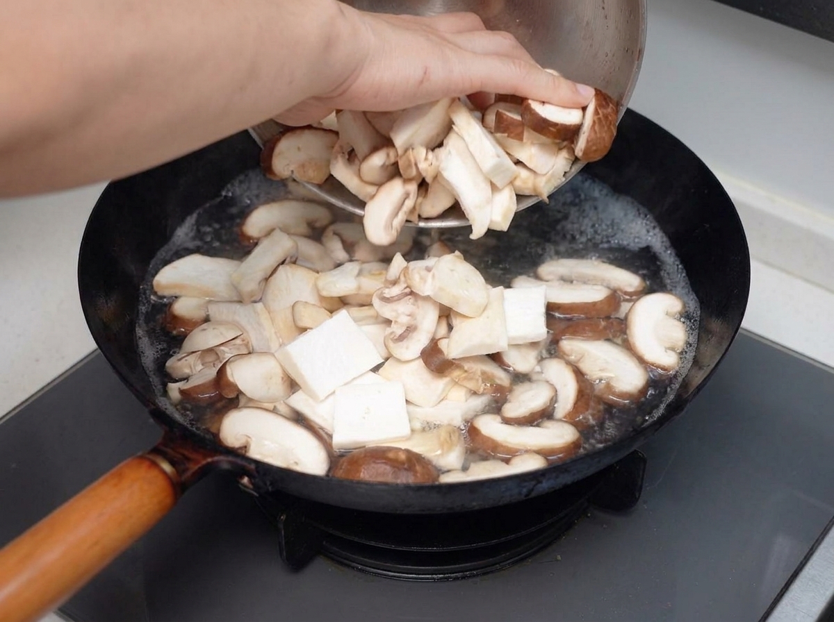 Funghi misti affettati versati in una pentola di acqua bollente.