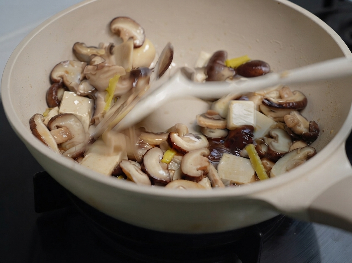 Funghi misti e zenzero saltati in padella con una spatola.