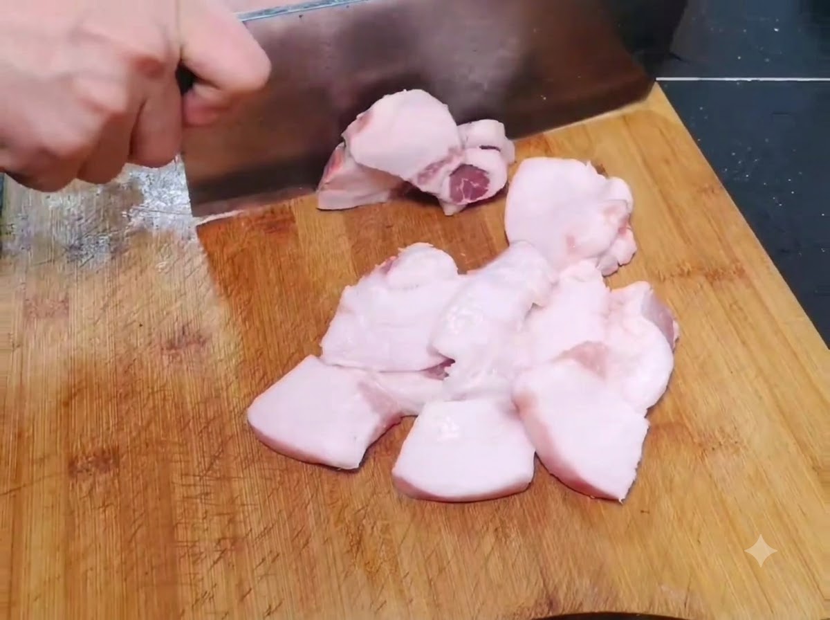 Fette sottili e larghe di maiale crudo tagliate su un tagliere di legno.