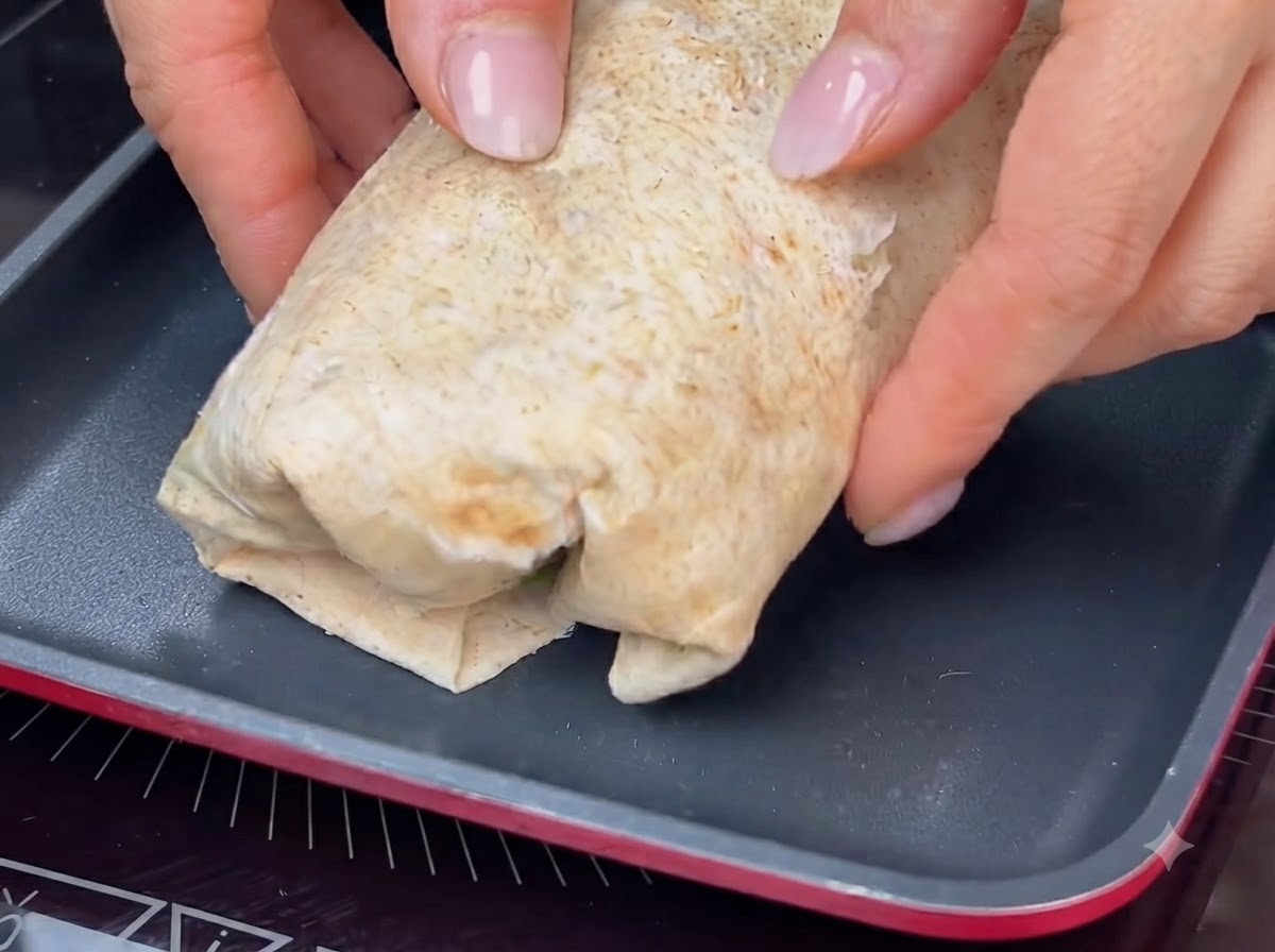 Un wrap arrotolato tostato in una padella calda per ottenere una crosticina dorata.