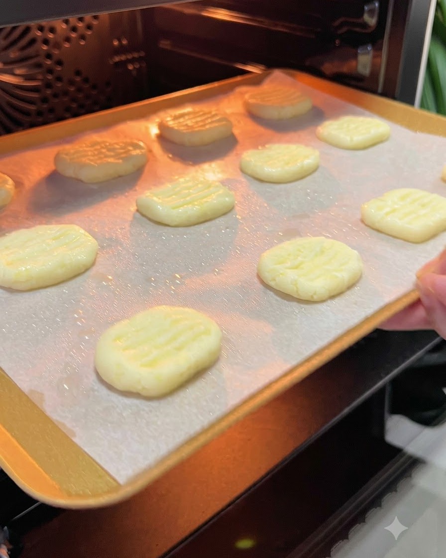 Una teglia con pancake di patate infilata nellinterno luminoso di un forno preriscaldato.