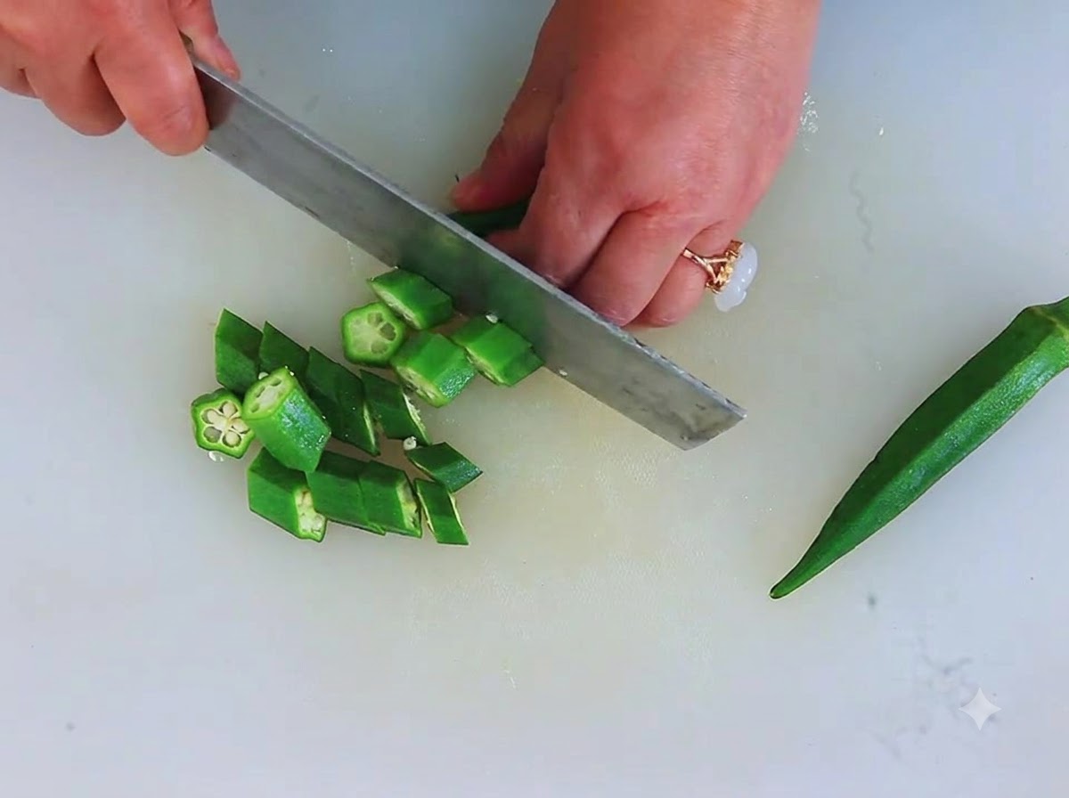Okra verde fresca tagliata a piccoli pezzi circolari a forma di stella su un tagliere.